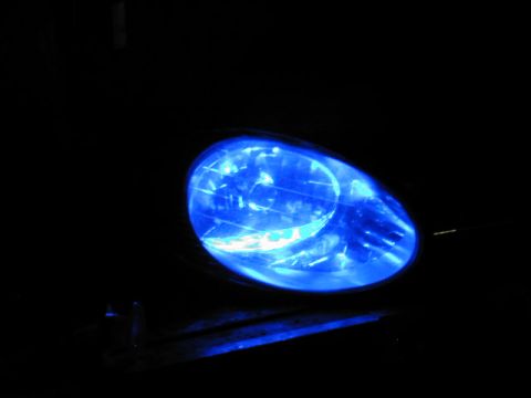 1998 Ford Taurus - Blue headlight bulb glowing in the dark, with Supermotors.net watermark.