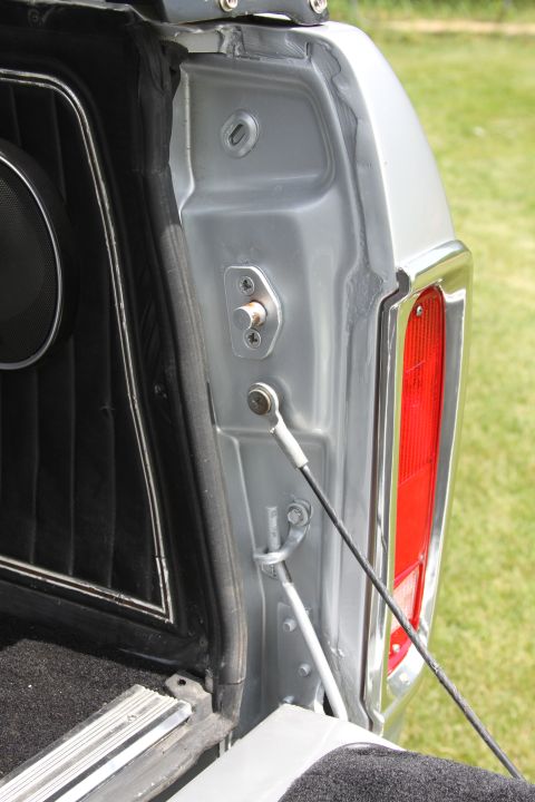 1979 Ford Bronco - Close-up of a vehicle's tailgate interior, showing the latch mechanism and a portion of the taillight assembly.