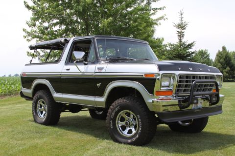 1979 Ford Bronco - This two-tone black and silver 1979 Ford Bronco features a black soft top and is shown from a three-quarter front view.
