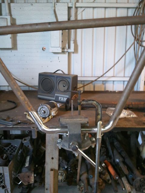 1982 Ford Bronco - A workbench scene shows a vise securing a metal pipe, with a small motor and a speaker nearby.