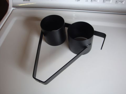 1989 Ford Bronco - A black metal dual cup holder with a triangular frame is shown against a white background.