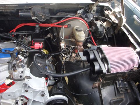 1989 Ford Bronco - Close-up view of a vehicle's engine bay, showing various components and aftermarket modifications.
