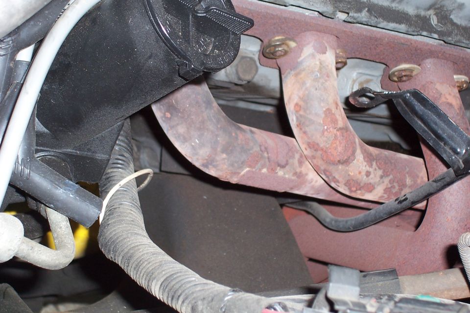 close-up of rusty exhaust manifold and some engine wiring