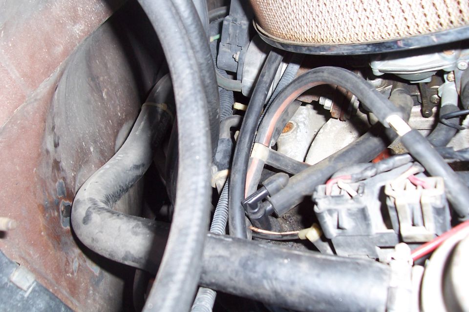 Engine bay with hoses, wiring, and air filter housing. Watermark reads www.supermotors.net