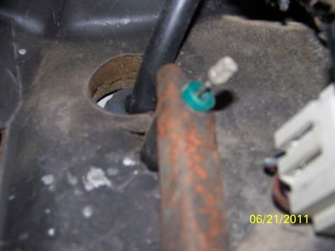 1989 Ford Bronco - A close-up view of interior vehicle components, including a rusty bracket and electrical connectors, dated 06/21/2011.