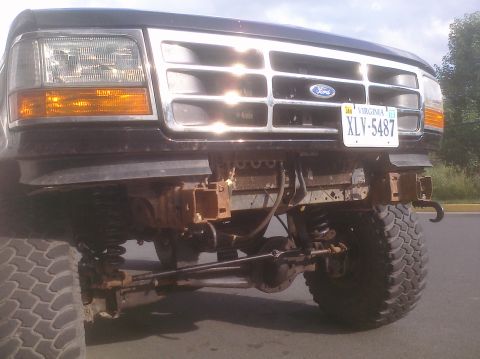 1995 Ford Bronco - The front of a 1995 Ford Bronco shows its grille and headlights, with the bumper removed to expose the suspension components.