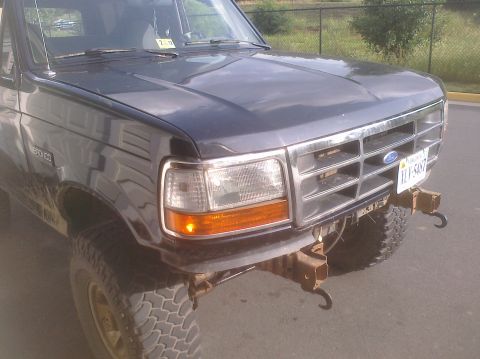 1995 Ford Bronco - The front of a dark gray Ford Bronco is shown with a chrome grille and a license plate.