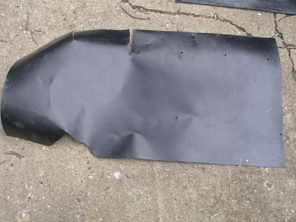 Bent black plastic splash shield on concrete