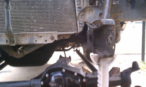 1990 Ford Bronco - Close-up view of a vehicle's front end, focusing on the radiator and suspension system during repair.
