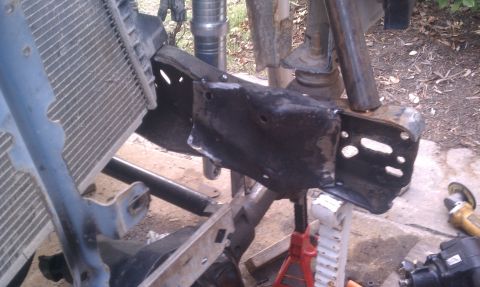 1990 Ford Bronco - Close-up of vehicle frame and radiator components, with a grinder in the background.