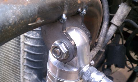 1990 Ford Bronco - Custom bracket attaches exhaust pipe to engine components, with radiator visible in the background.