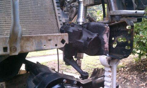 1990 Ford Bronco - Close-up view of a steering box and radiator assembly, possibly undergoing repair or modification.
