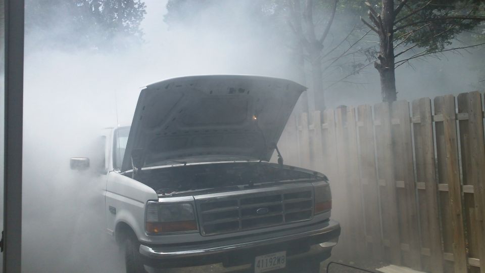White Ford F-Series truck with hood open, emitting smoke. License plate reads 41192WB