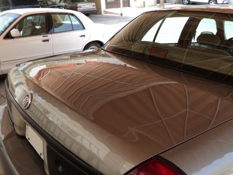 2001 Mercury Grand Marquis - Rear view of a 2001 Mercury Grand Marquis, showing the trunk and rear window with reflections.