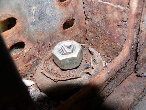 1976 Chevrolet Corvette - A close-up view of a heavily corroded metal component with a single nut, showing significant rust damage.