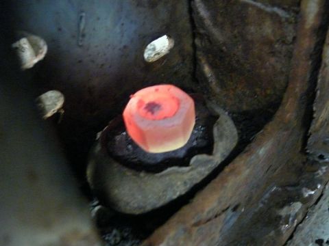 1976 Chevrolet Corvette - A close-up view shows a bolt head glowing red hot amidst heavily rusted metal components.
