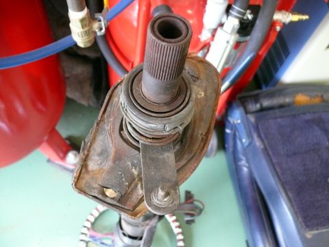 1976 Chevrolet Corvette - A close-up view of a rusty steering column part, likely from an older vehicle, with visible mechanical components.