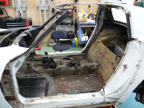 1976 Chevrolet Corvette - The interior of a 1976 Chevrolet Corvette is shown stripped down for restoration, revealing its chassis and components.