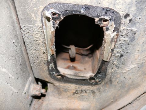 1976 Chevrolet Corvette - Close-up view of the underside of a vehicle, revealing a corroded access panel.