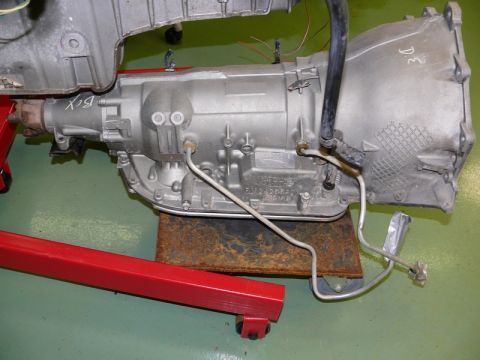 1976 Chevrolet Corvette - An automatic transmission is mounted on a red engine stand for repair or inspection.
