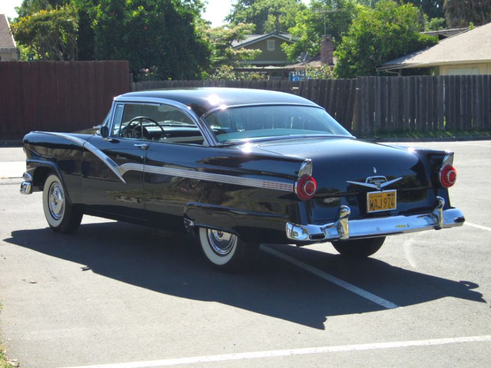 Dark blue 1956 Ford Fairlane rear 3/4 view with chrome accents and whitewall tires