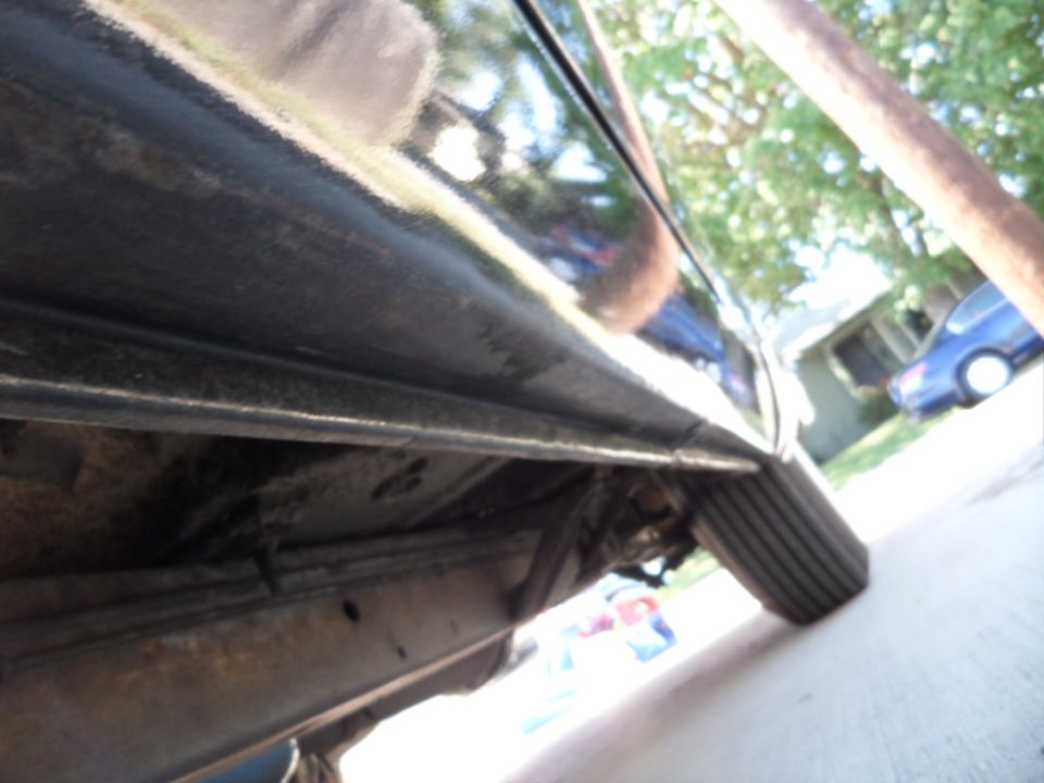 Black 1956 Ford Fairlane side view showing the lower body and tire