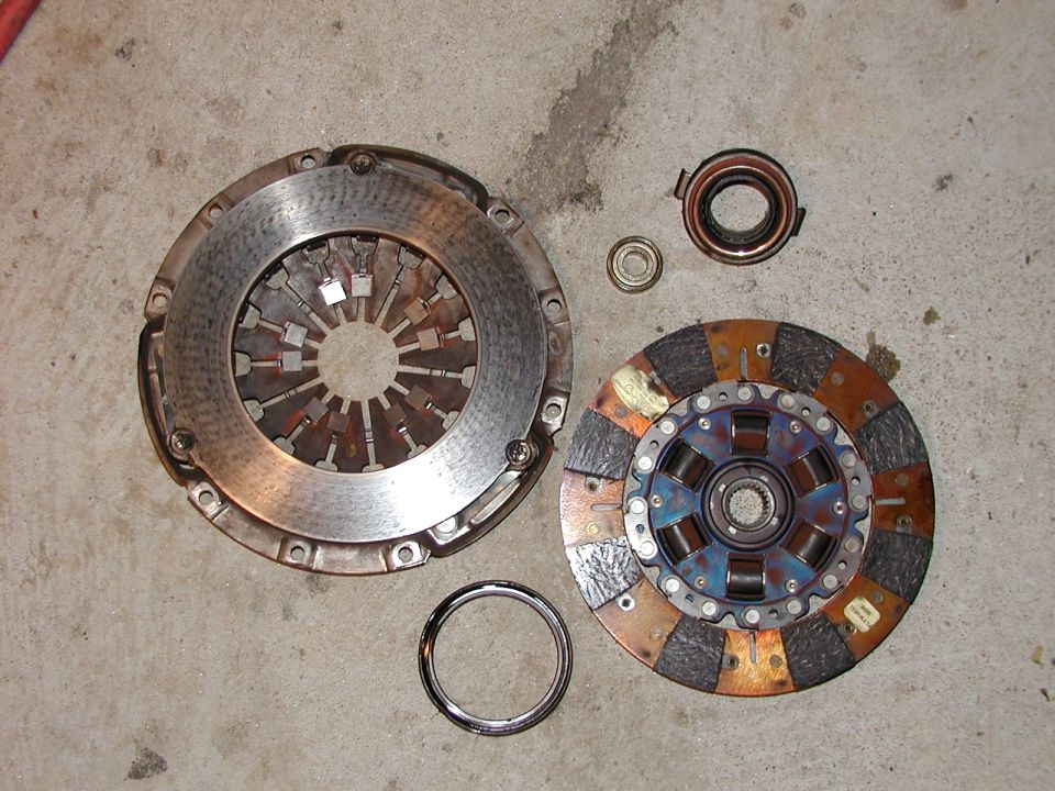 Clutch disc, pressure plate, and release bearing laid out on concrete