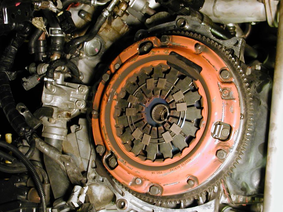 Engine clutch assembly with orange pressure plate and visible friction disc