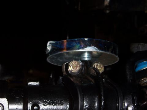1992 Ford Bronco - A close-up view of a vehicle's steering component, a chrome cap secured by bolts.
