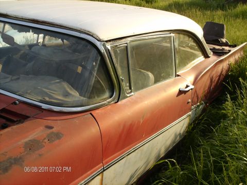 1958 Ford Fairlane - This 1958 Ford Fairlane, seen from the side, features distinctive tail fins and a two-tone red and white paint scheme.