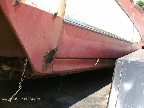 1958 Ford Fairlane - Close-up of the lower body panel and trim on a 1958 Ford Fairlane, showing rust damage.