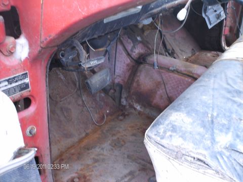 1958 Ford Fairlane - The interior of an old car shows significant rust and wear on the floor and dashboard components.