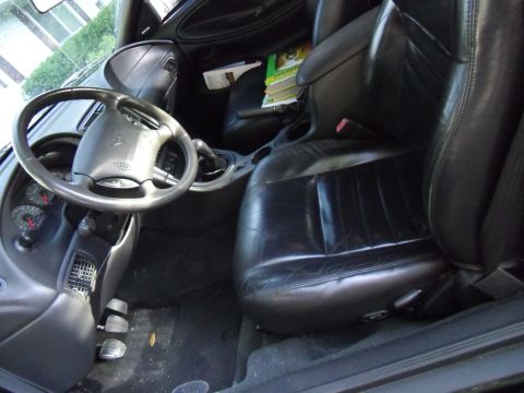 1978 Ford Bronco - The interior of a car is shown, black leather seats and the driver's side controls.