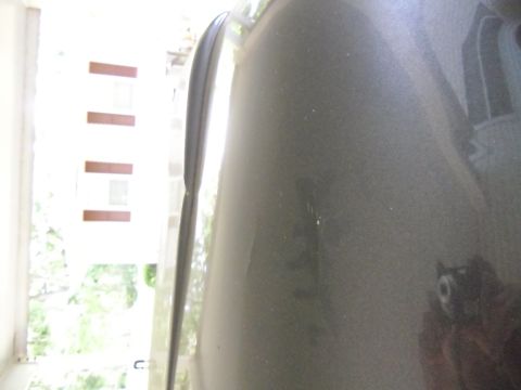 1978 Ford Bronco - Close-up view of a gray vehicle's fender, showing minor imperfections and a reflection.