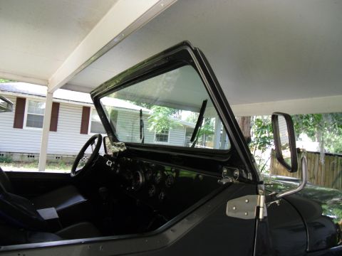 1978 Ford Bronco - The interior of a vintage SUV is visible, a steering wheel and multiple gauges on the dashboard.