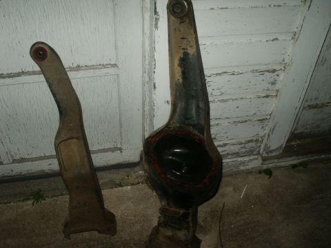 1990 Ford Bronco - Two old automotive suspension parts are shown against a weathered white door, with a website watermark at the bottom right.