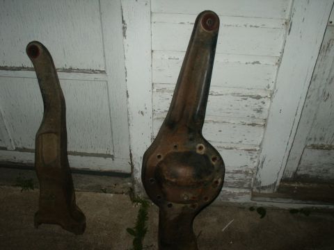 1990 Ford Bronco - Two rusty metal automotive parts are shown in front of a weathered white door.