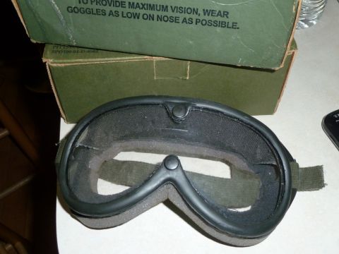 1992 Ford Mustang - Goggles with a green strap and foam padding are shown in front of a green box with text.