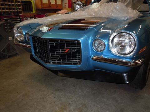 1972 Chevrolet Camaro - Front view of a blue Chevrolet Camaro Z28 with a distinctive grille and hood stripes, partially covered.