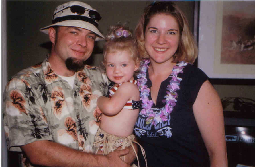 Family posing for a photo, man holding a child