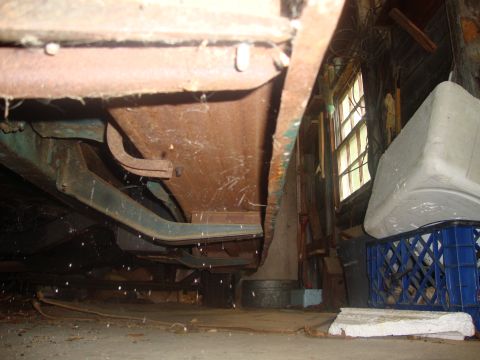 2002 Chevrolet Silverado 1500 - The rusty undercarriage of a classic truck is visible, with a workshop setting in the background.