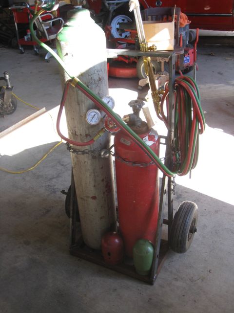 1994 Ford Bronco - A welding cart holds oxygen and acetylene tanks, regulators, and hoses, with a torch attached.