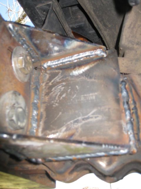 1994 Ford Bronco - Close-up view of a heavily welded metal component, likely part of a vehicle's frame or suspension system.