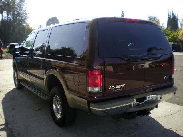 Dark red 2000 Ford Excursion rear view with tinted windows and chrome bumper