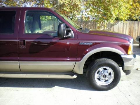2000 Ford Excursion - This maroon Ford Excursion SUV is shown from the front three-quarter angle, highlighting its two-tone paint scheme and running boards.