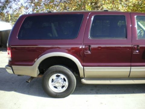 2000 Ford Excursion - The side profile of a maroon 2000 Ford Excursion SUV shows its two-tone paint scheme and large windows.
