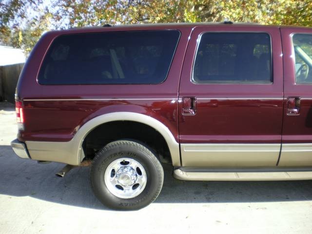 Maroon 2000 Ford Excursion SUV with tan lower body trim, side view, parked outdoors