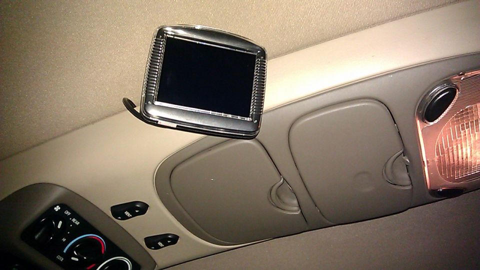 Tan SUV overhead console with flip-down LCD screen, dome light, and rear climate knobs