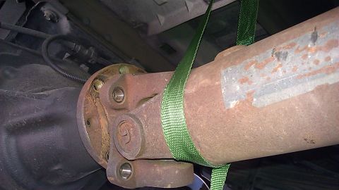 2000 Ford Excursion - Close-up of a vehicle's driveshaft and differential assembly, secured with straps.