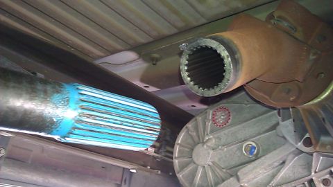 2000 Ford Excursion - Underside view of a vehicle's driveshaft and transfer case, showing mechanical components.
